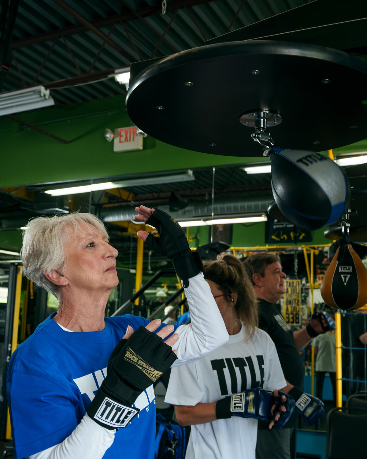 variant:lifestyle::TITLE Boxing Rock Steady Gel Glove Wraps lady hitting speed bag