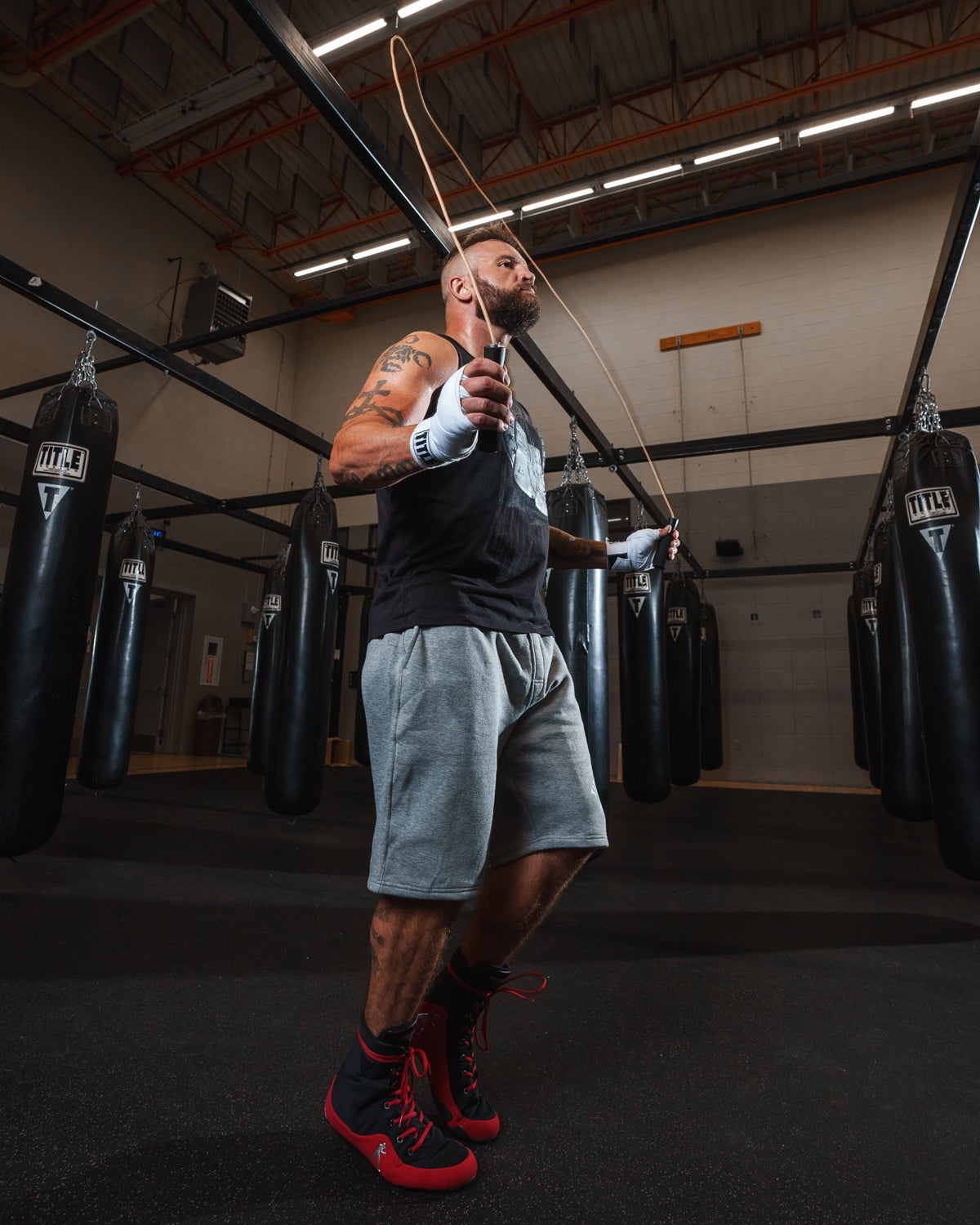 variant:lifestyle::TITLE Classic Leather Speed Rope 2.0 guy holding jump rope guy jumpropes