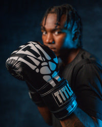 variant:black::TITLE Boxing Skeleton Hand Bag Boxing Gloves on boxer's hand closeup