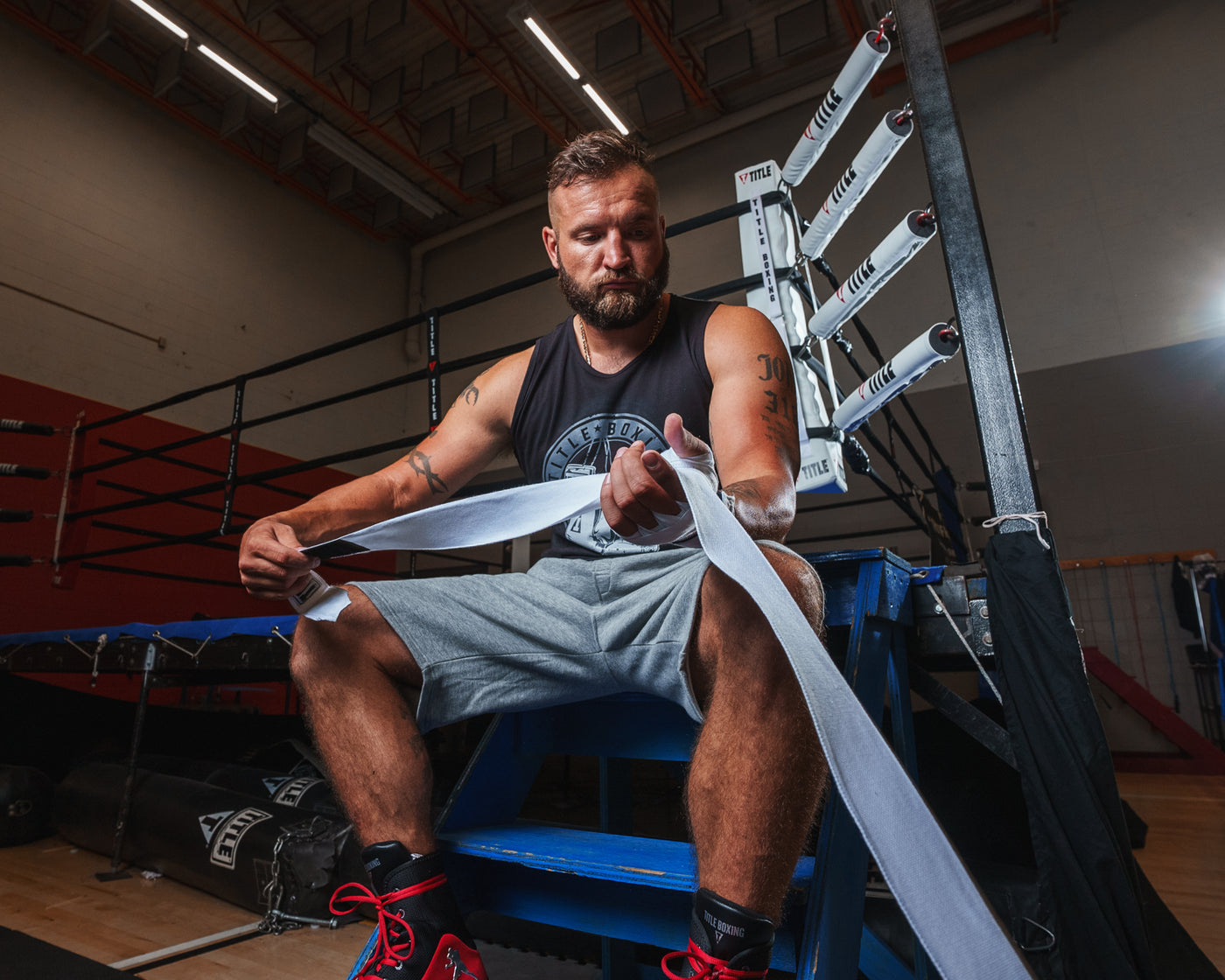 variant:white::TITLE Boxing Select 180" Semi Elastic Mexican Hand Wraps guy unrolling wrap