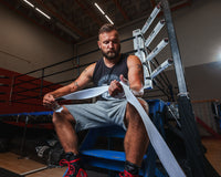 variant:white::TITLE Boxing Select 180" Semi Elastic Mexican Hand Wraps guy unrolling wrap