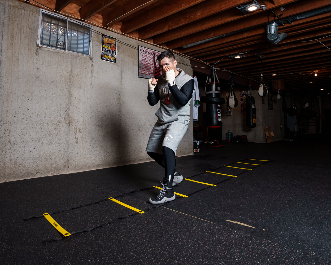 variant:lifestyle::TITLE Boxing Speed & Agility Ladder on the floor of a boxing gym