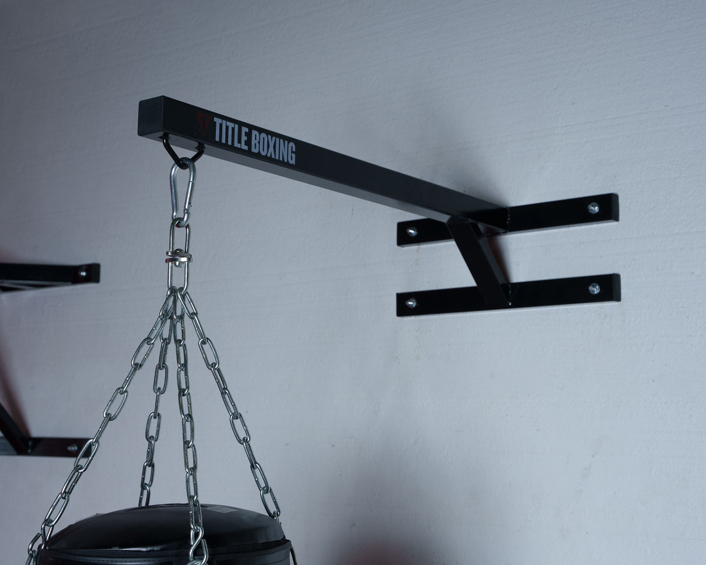 variant:lifestyle::TITLE Boxing Space Saver Wall Mount Bag Hanger 2.0 in use with a heavy bag