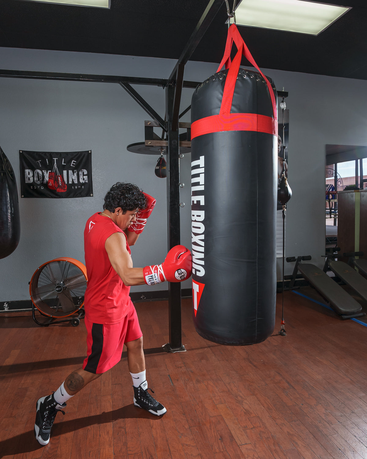 variant:lifestyle::TITLE Boxing Titanic Flex-Strike Heavy Bag man hitting bag