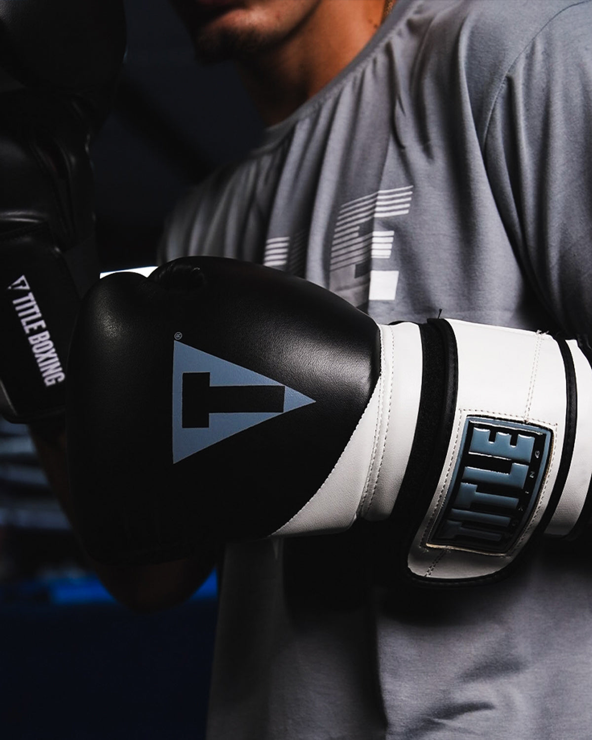 variant:Black/White::TITLE Boxing Swift Bag Boxing Gloves closeup on gloves on fighter's hands