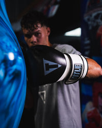 variant:Black/White::TITLE Boxing Swift Bag Boxing Gloves on boxer's hand hitting punching bag closeup