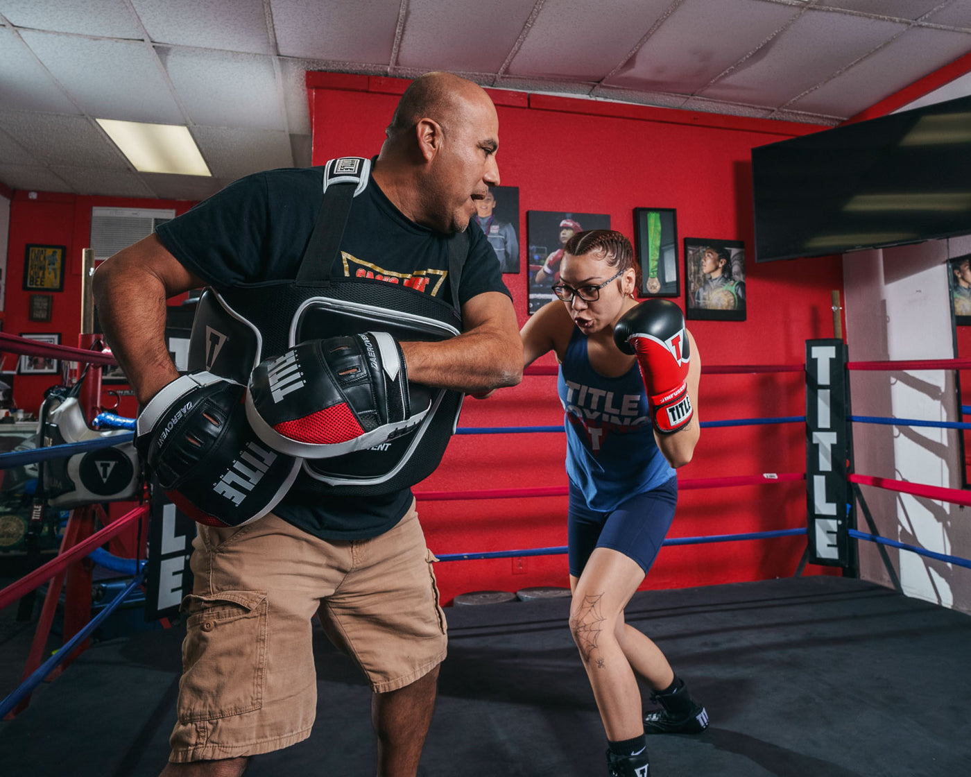 variant:lifestyle::TITLE Boxing Aerovent Excel Incredi-Mitts 2.0 boxer and coach hitting back and forth girl and coach 