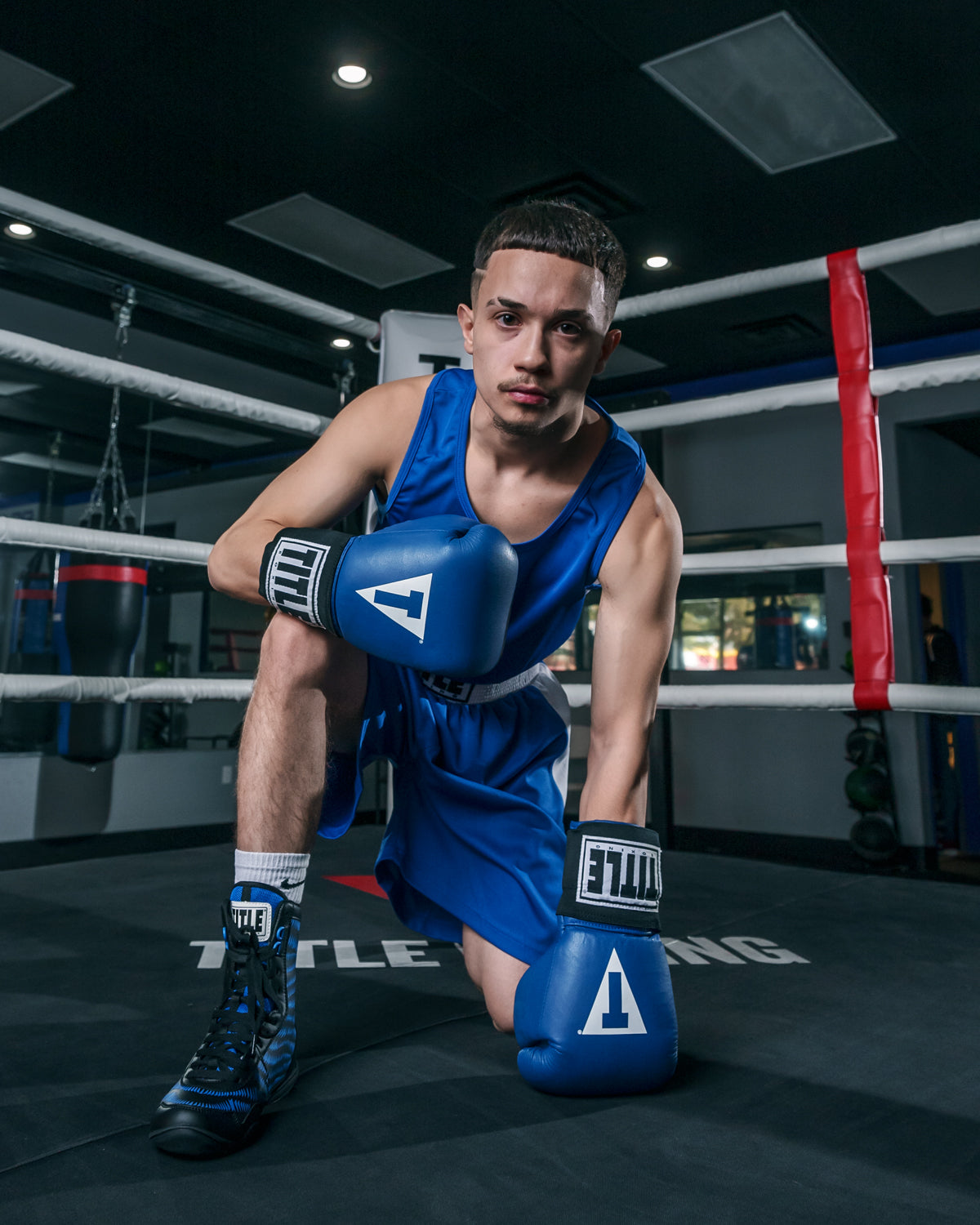 variant:Black/Blue::TITLE Boxing Predator Shoes 2.0 kid kneeling on ring