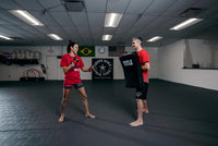 variant:lifestyle::TITLE Boxing Pro Punch Shield 2.0 coach with lady