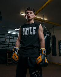 variant:Black/White::TITLE Boxing Iconic Block Muscle Tee man posing in tee with gloves on 