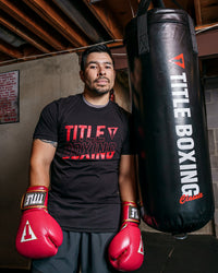variant:Black::TITLE Boxing Upsurge Tee guy posing against a bag