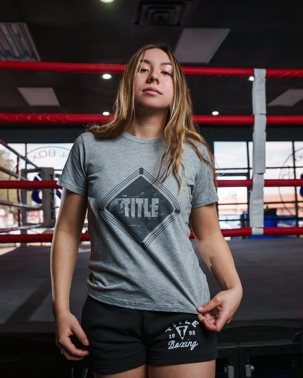variant:grey::TITLE Boxing Women's Snapshot tee girl standing infront of ring