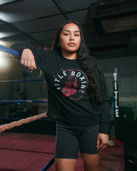 variant:Black::TITLE Boxing Women's Signal Crewneck Sweatshirt girl in a pose leaning on ropes