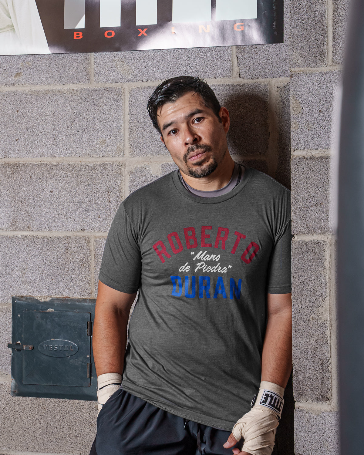 variant:grey::TITLE Boxing Legacy Roberto Duran "Mano De Piedra"Tee guy posing against the wall