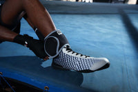 variant:lifestyle::TITLE Boxing Pro Ankle Weights sitting down putting on ankle
