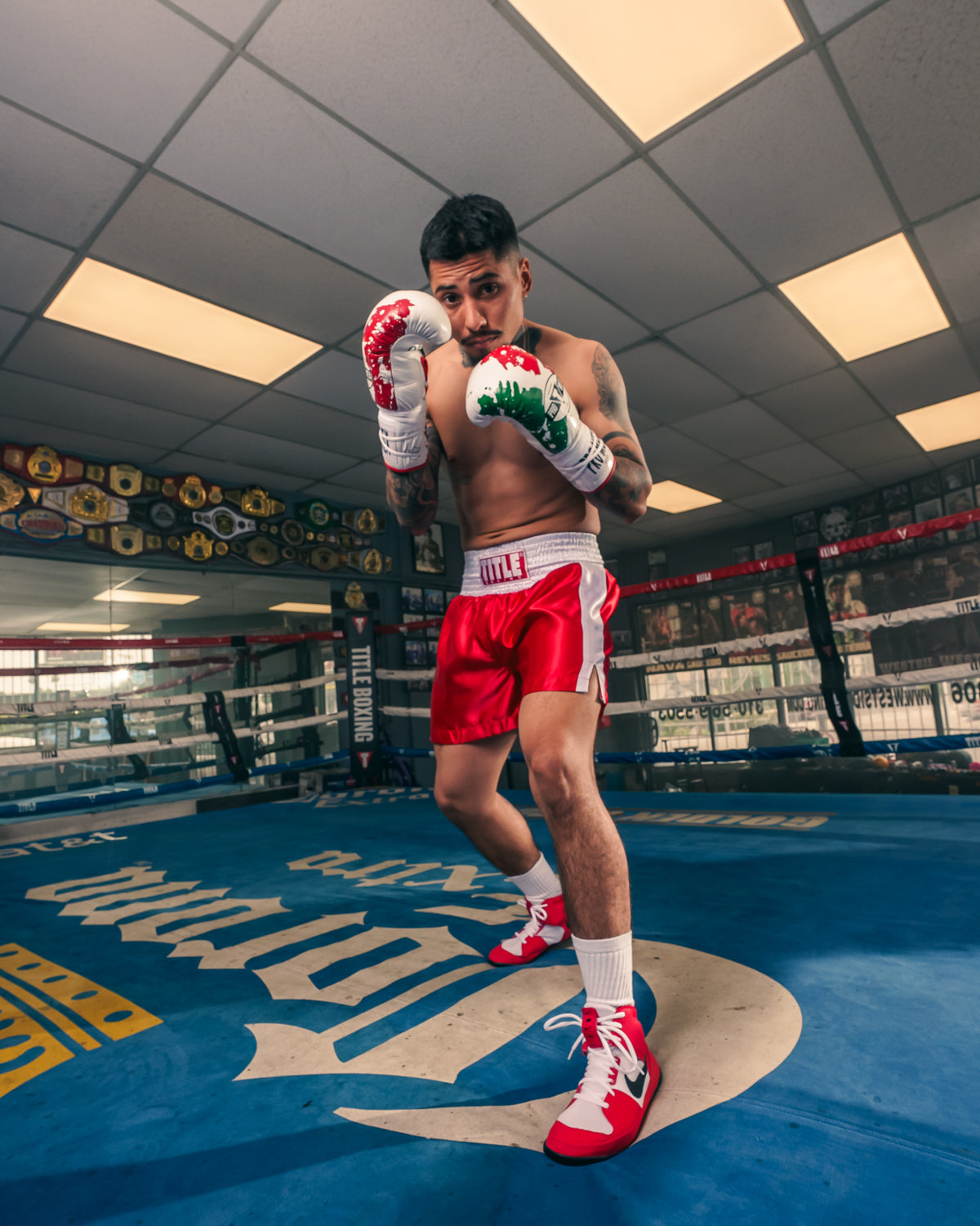 variant:red/White::TITLE Boxing Pro Traditional Cut Trunks guy posing in ring hands up