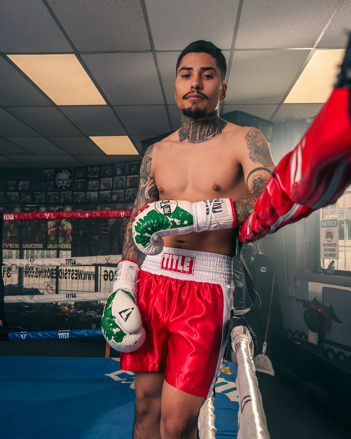 variant:red/White::TITLE Boxing Pro Traditional Cut Trunks guy posing in ring resting arm on rope