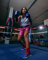variant:pink/black::TITLE Boxing Professional Women’s Satin Striped Boxing Trunks girl in ring boxing pose