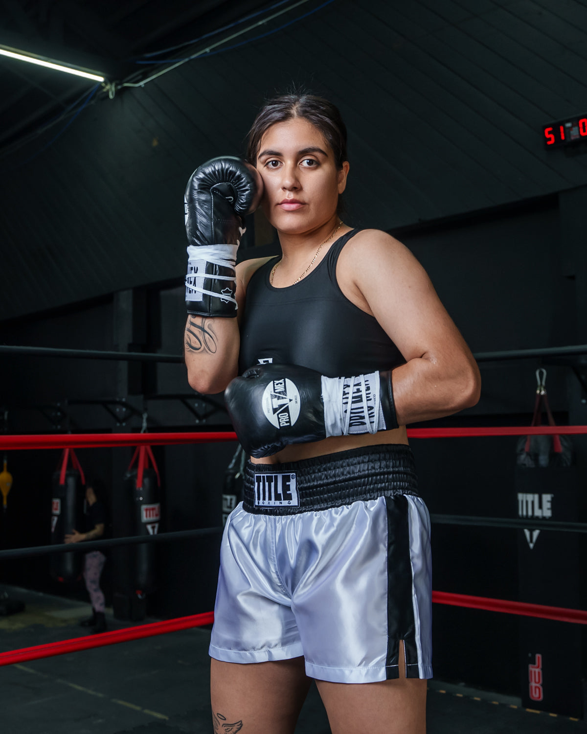 variant:White/Black::TITLE Boxing Professional Women’s Satin Striped Boxing Trunks  a girl posing in trunks