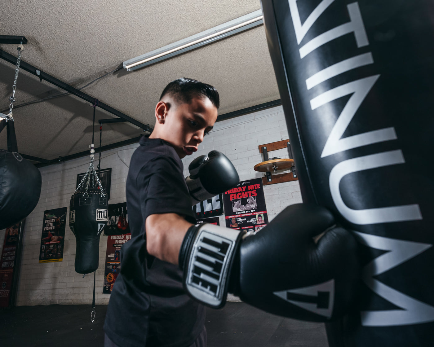 variant:Black/White::TITLE Premier Leather Super Bag Gloves 2.0 being used in heavy bag training