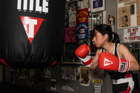 variant:Red/White::TITLE Boxing Pro Style Leather Training Gloves 3.0 girl hitting bag