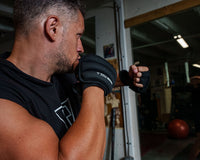 variant:black::TITLE Boxing Weighted Gloves 2.0 guy shadow boxing