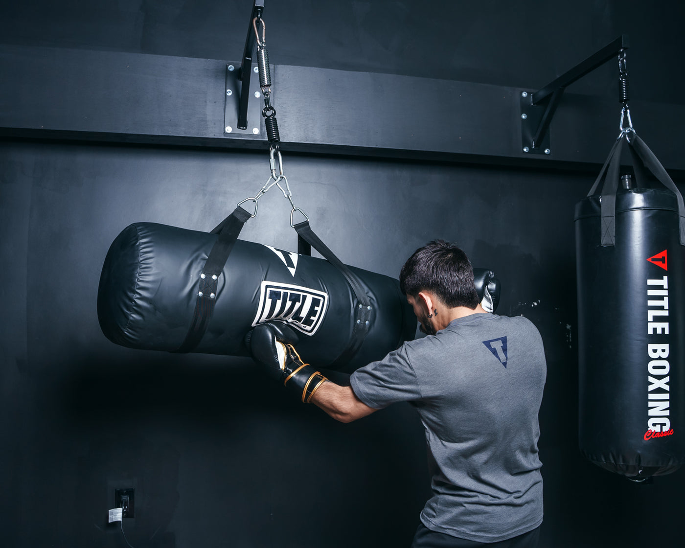 variant:Black::TITLE Boxing Synthetic Leather Uppercut Heavy Bag guy hitting the bag
