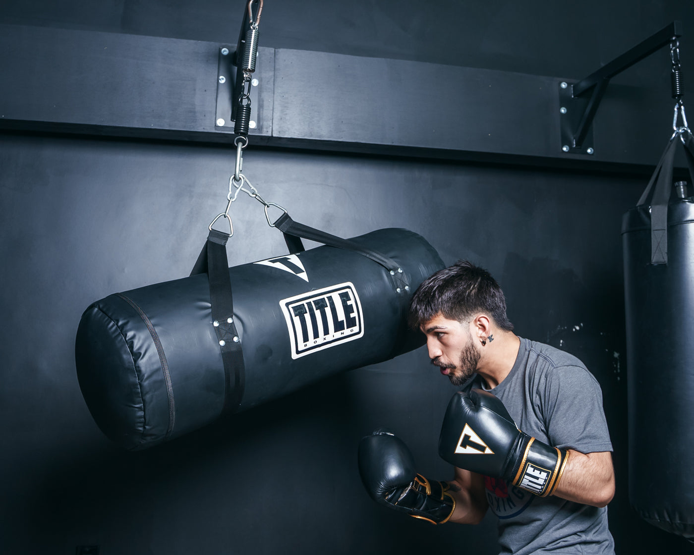 variant:Black::TITLE Boxing Synthetic Leather Uppercut Heavy Bag guy hitting the bag