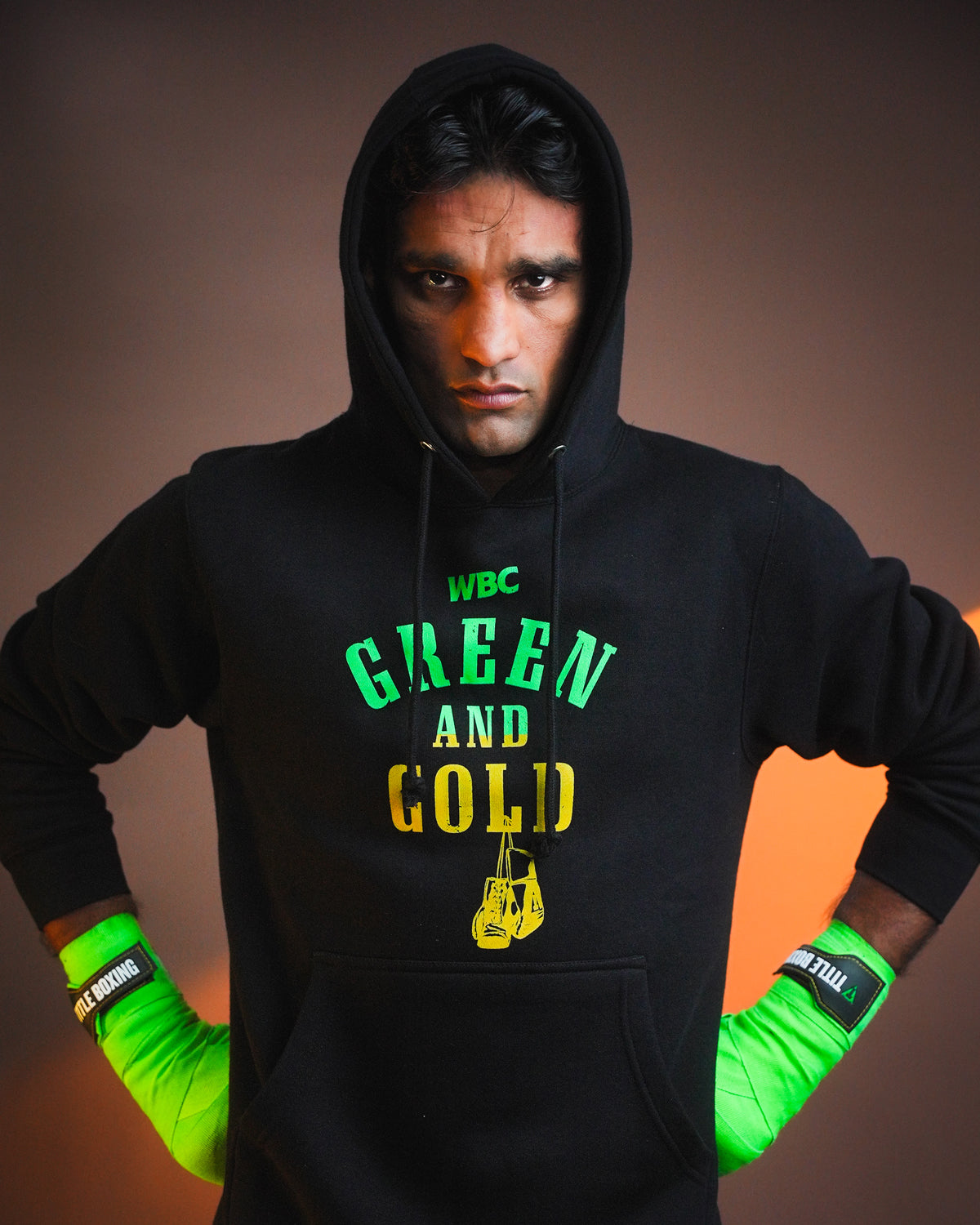 variant:lifestyle::WBC By TITLE Boxing Green & Gold Hoodie on boxer with hood up standing
