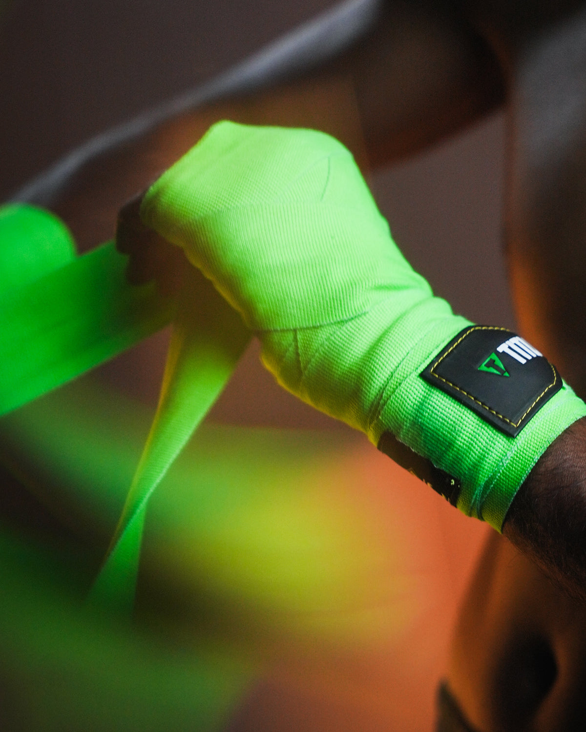 variant:Green/Black::WBC by TITLE Boxing Hand Wraps on boxer's hands being wrapped closeup