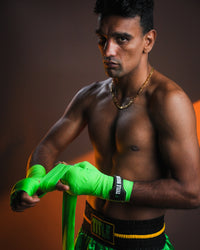 variant:Green/Black::WBC by TITLE Boxing Hand Wraps on boxer's hands being wrapped 