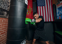 variant:Green/Black::WBC by TITLE Boxing Sparring Gloves man hitting bag left jab