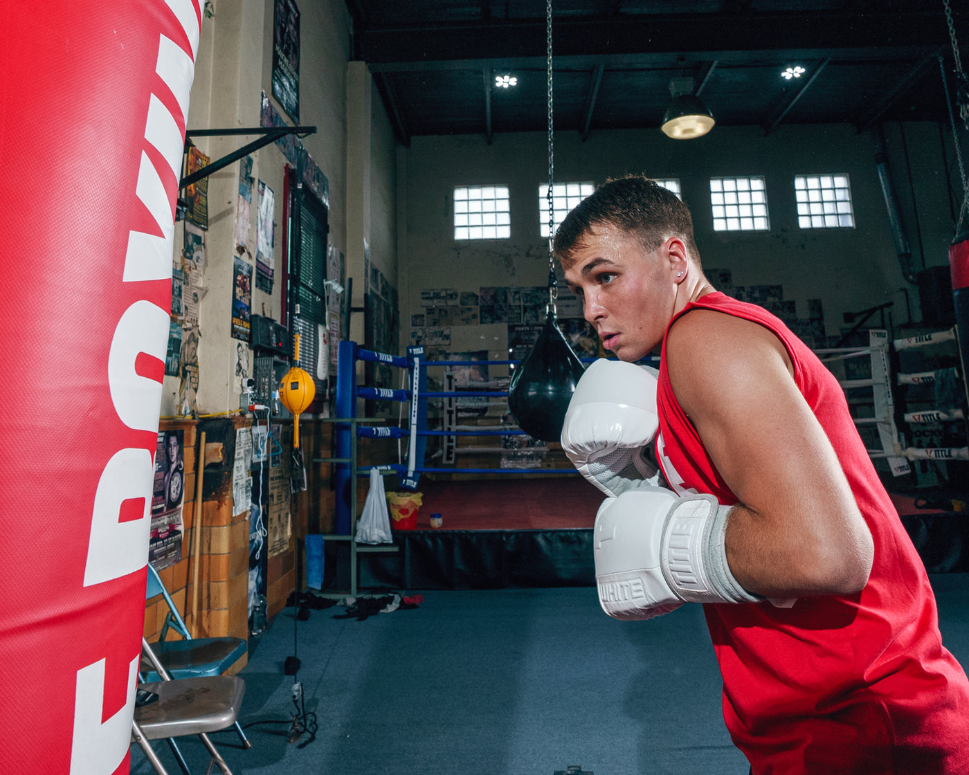 variant:lifestyle::TITLE White Boxing Heavy Bag Gloves guy boxing with bag