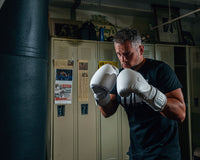 variant:lifestyle::TITLE White Boxing Training Gloves 2.0  guy hitting bag