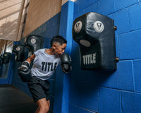 variant:lifestyle::TITLE Boxing Wall Mount Menace Training Bag in use on a boxing gym wall