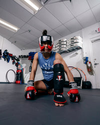 variant:lifestyle::TITLE MMA Command Training Headgear girl sitting on ground