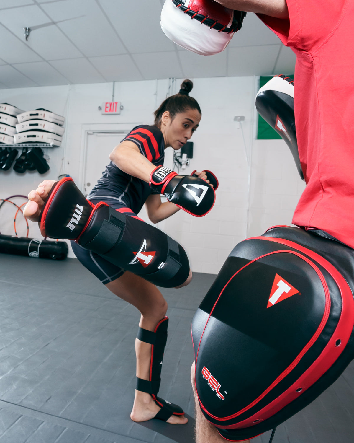 variant:lifestyle::TITLE MMA Conflict Stand Up Shin Guards lady kicking shin guards