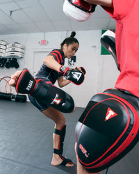 variant:lifestyle::TITLE MMA Conflict Stand Up Shin Guards lady kicking shin guards