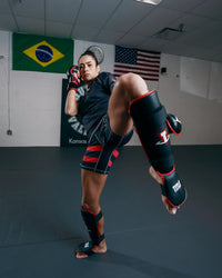 variant:lifestyle::TITLE MMA Conflict Stand Up Shin Guards lady kicking pose