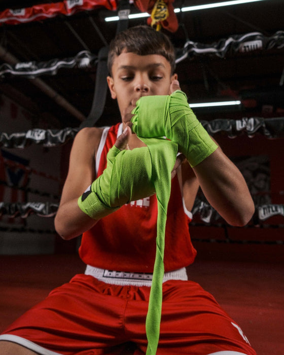 variant:lifestyle::Fighting Sports Gloves and Wraps Bundle kid boxer wrapping hands with green wraps