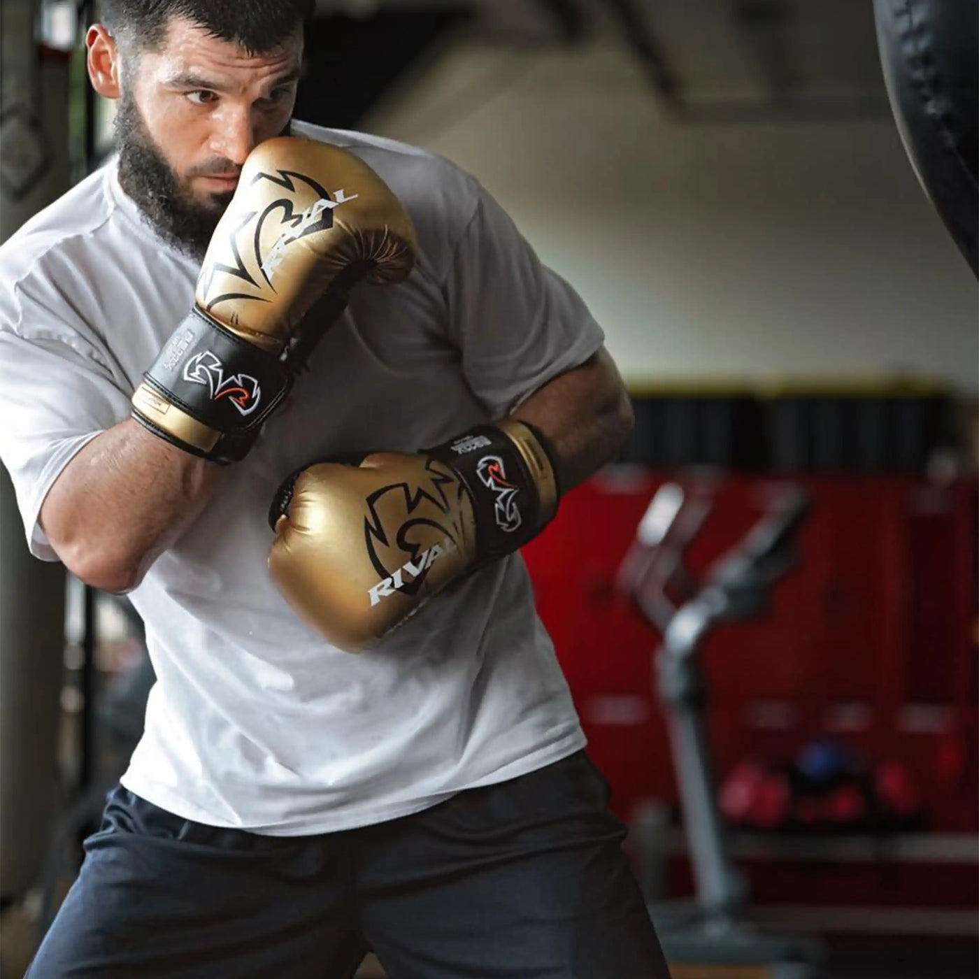 variant:Gold::Man wearing boxing gloves in a gym setting