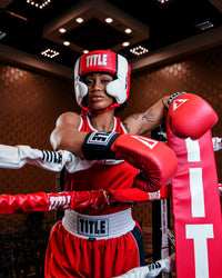 variant:red::TITLE Boxing Aerovent Elite USA Boxing Competition Headgear – With Cheeks woman in a ring