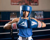 variant:blank blue::TITLE Boxing USA Boxing Competition Headgear - Open Face kid in ring hands together