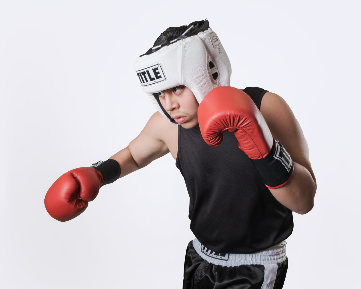 variant:white::TITLE Boxing USA Boxing Competition Headgear - Open Face throwing a right hook