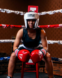 variant:white::TITLE Boxing USA Boxing Competition Headgear - Open Face kid sitting on stool 