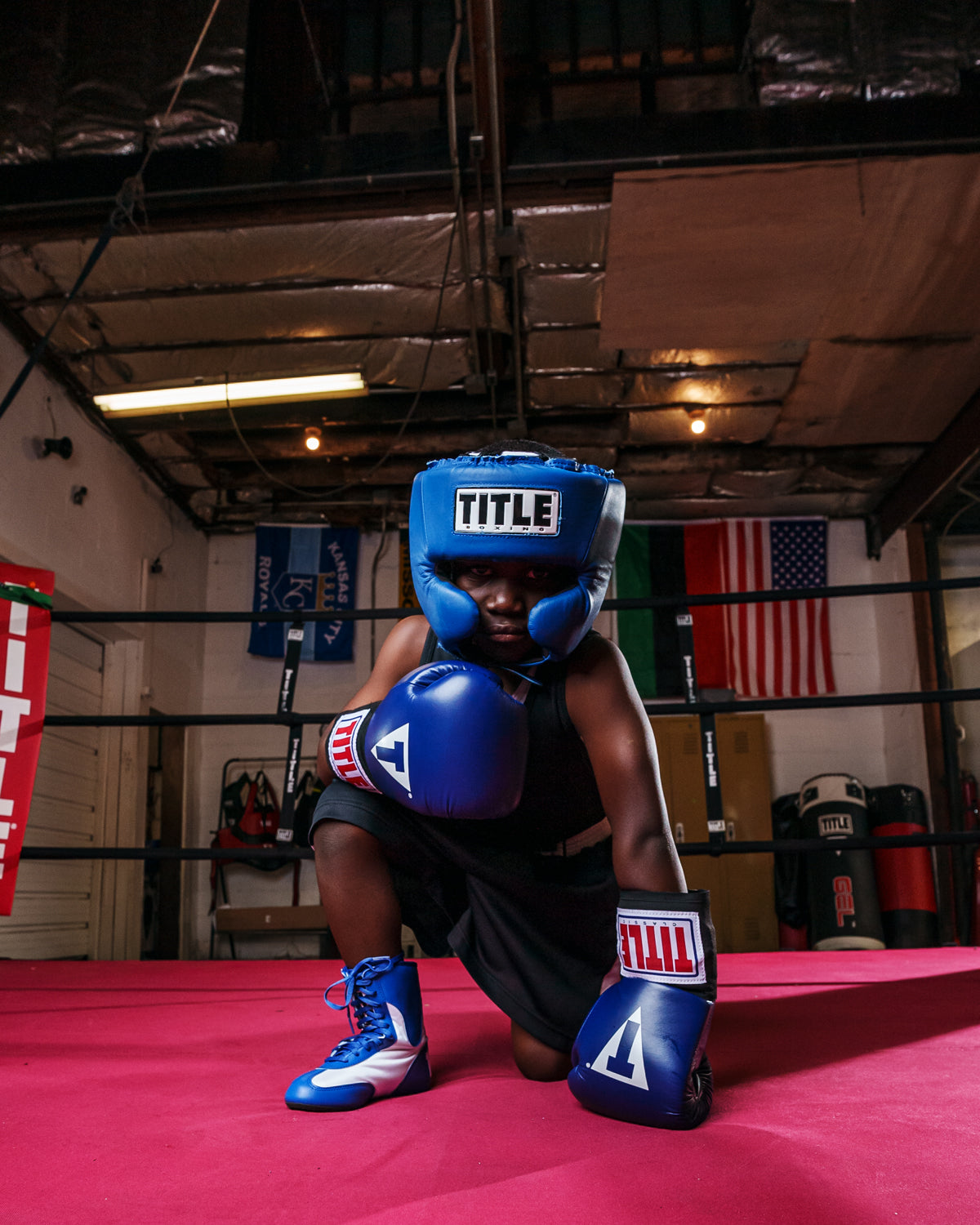 variant:blue::TITLE Boxing USA Boxing Competition Headgear - With Cheeks kid kneeling in ring