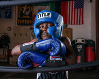 variant:blue::TITLE Boxing USA Boxing Competition Headgear - With Cheeks guy standing on ropes