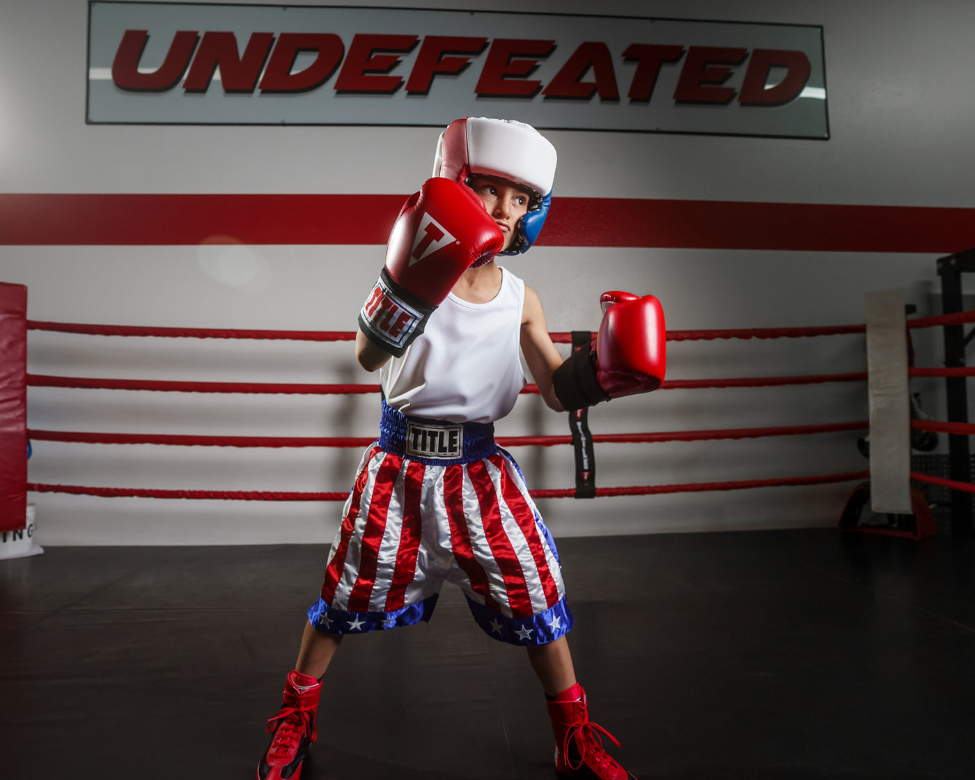 variant:Blank Red/White/Blue::TITLE Boxing USA Boxing Competition Headgear - With Cheeks kid posing in ring