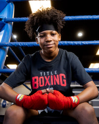 variant:red::BOOM BOOM Boxing Youth Flex Hand Wraps kid hands together sitting in ring