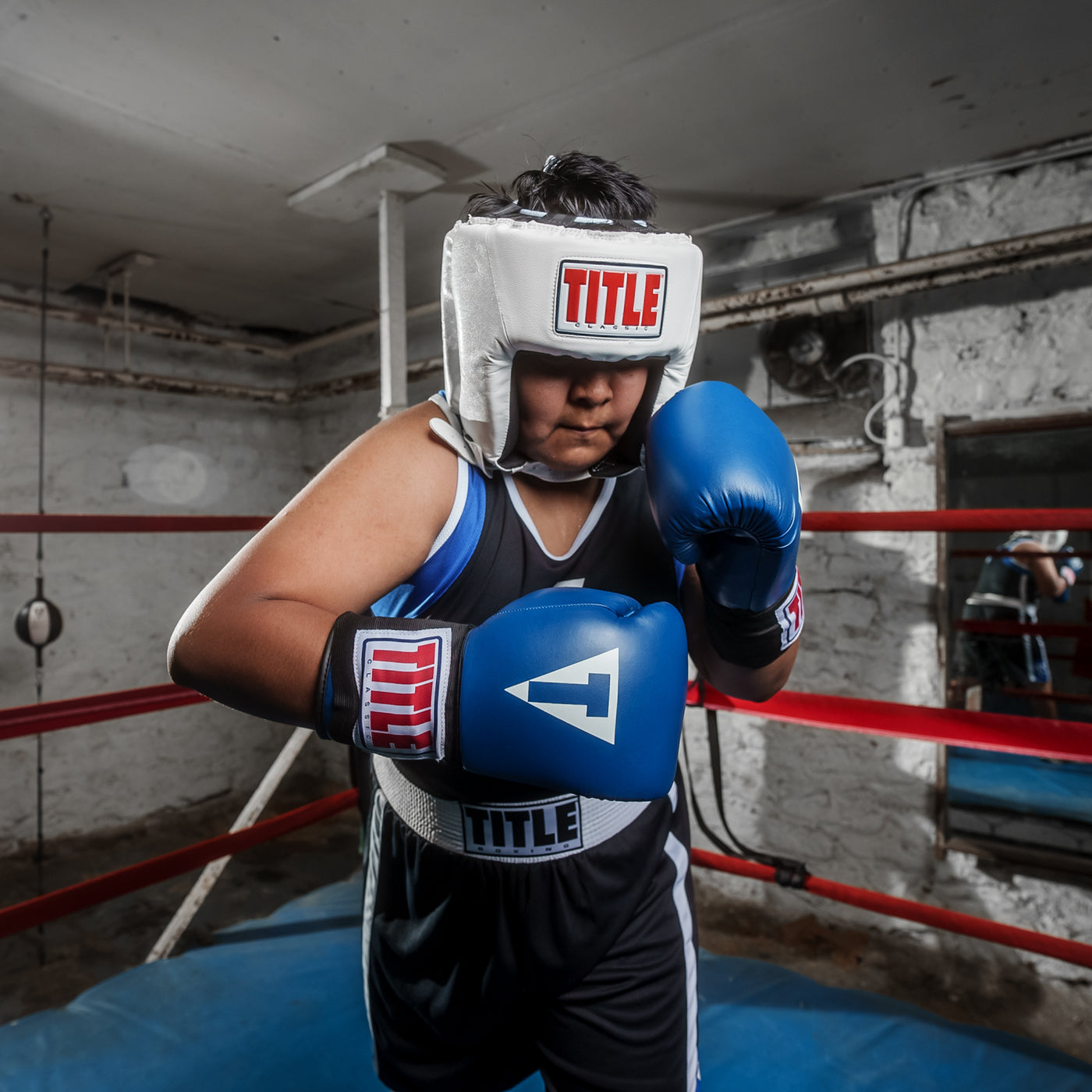 variant:white::TITLE Classic USA Boxing Competition Headgear – Open Face kid with blue gloves in ring